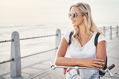 Buy stock photo Shot of a beautiful young woman out on the promenade with her bicycle
