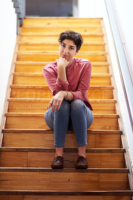 Buy stock photo Full length portrait of an attractive young businesswoman sitting alone on a wooden staircase in her office