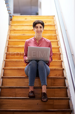 Buy stock photo Full length portrait of an attractive young businesswoman sitting alone on a staircase and using her laptop in the office
