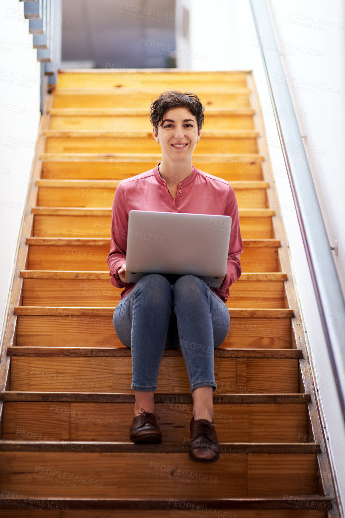 Buy stock photo Full length portrait of an attractive young businesswoman sitting alone on a staircase and using her laptop in the office