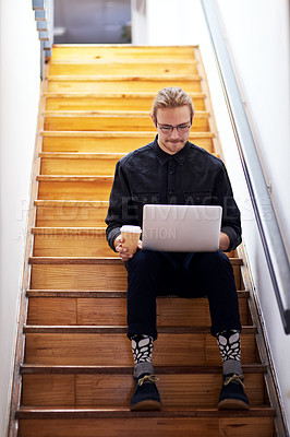 Buy stock photo Full length shot of a handsome young businessman sitting alone on the staircase alone and using his laptop