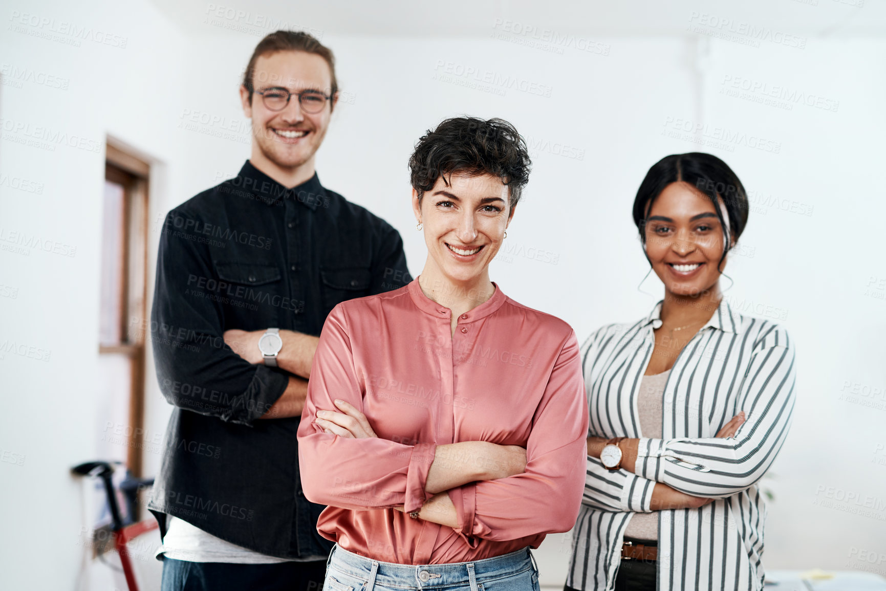 Buy stock photo Cropped portrait of a diverse group of businesspeople standing in the office together with their arms folded