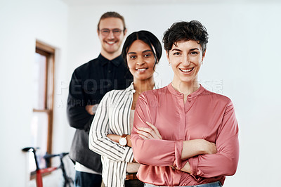Buy stock photo Cropped portrait of a diverse group of businesspeople standing in a line with their arms folded in the office