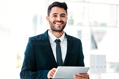 Buy stock photo Cropped portrait of a handsome young businessman smiling while holding a digital tablet in a modern office