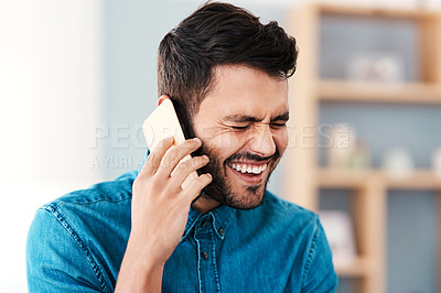 Buy stock photo Cropped shot of a handsome young man laughing while taking a phonecall in his living room at home
