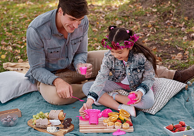 Buy stock photo Shot of an adorable little girl having a tea party in the park with her father