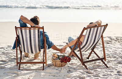 Buy stock photo Rearview shot of a middle aged couple sitting in their beach chairs on the the beach