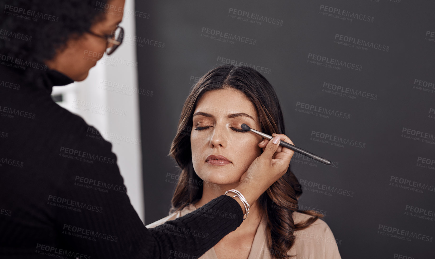 Buy stock photo Beauty brush, makeup artist and woman with eyeshadow design, facial cosmetics service and studio skincare routine. Spa salon, cosmetology client or person apply face treatment, product or wellness