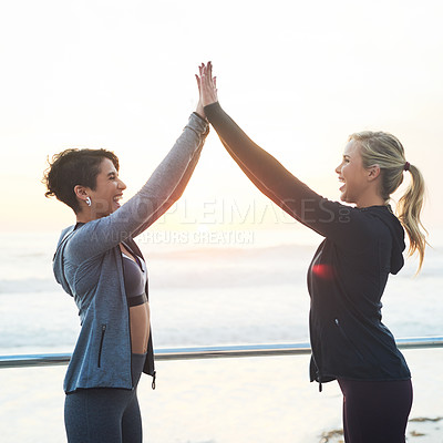 Buy stock photo Cropped shot of two young women giving each other a high five after their run