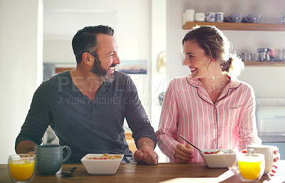 Buy stock photo Happy couple, laughing or eating breakfast with cereal, diet or juice in morning meal in home kitchen. People, trust or snack in bowl for bonding, funny joke and food in healthy marriage together