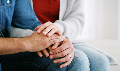 Buy stock photo Cropped shot of an unrecognizable couple sitting together at home