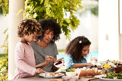 Buy stock photo Cropped shot of a young woman enjoying a meal with her children at home