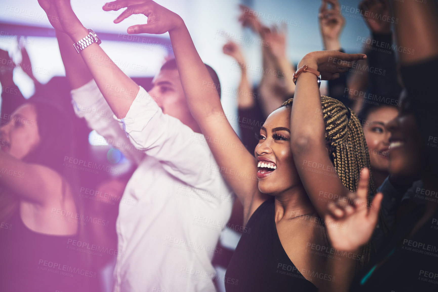 Buy stock photo Cropped shot of an attractive young woman cheering while standing in the crowd at a concert at night