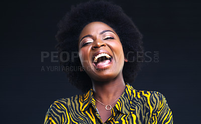 Buy stock photo Shot of a young woman laughing while posing against a dark background