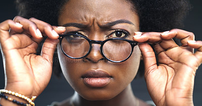 Buy stock photo Cropped shot of a woman adjusting her glasses against a dark background