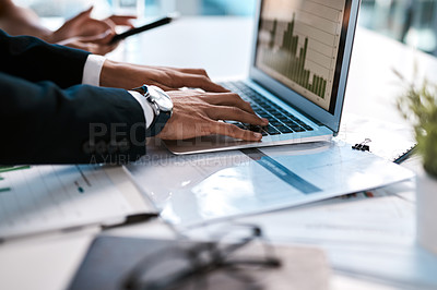 Buy stock photo Cropped shot of an unrecognizable businessman sitting with his female colleague in his office and typing on his laptop