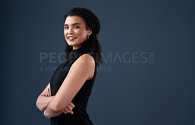 Buy stock photo Cropped portrait of an attractive young businesswoman standing against a gray background alone with her arms folded