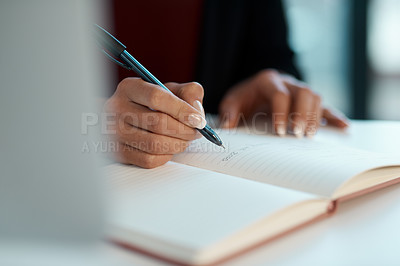 Buy stock photo Cropped shot of an unrecognizable businesswoman sitting alone and writing notes in her office