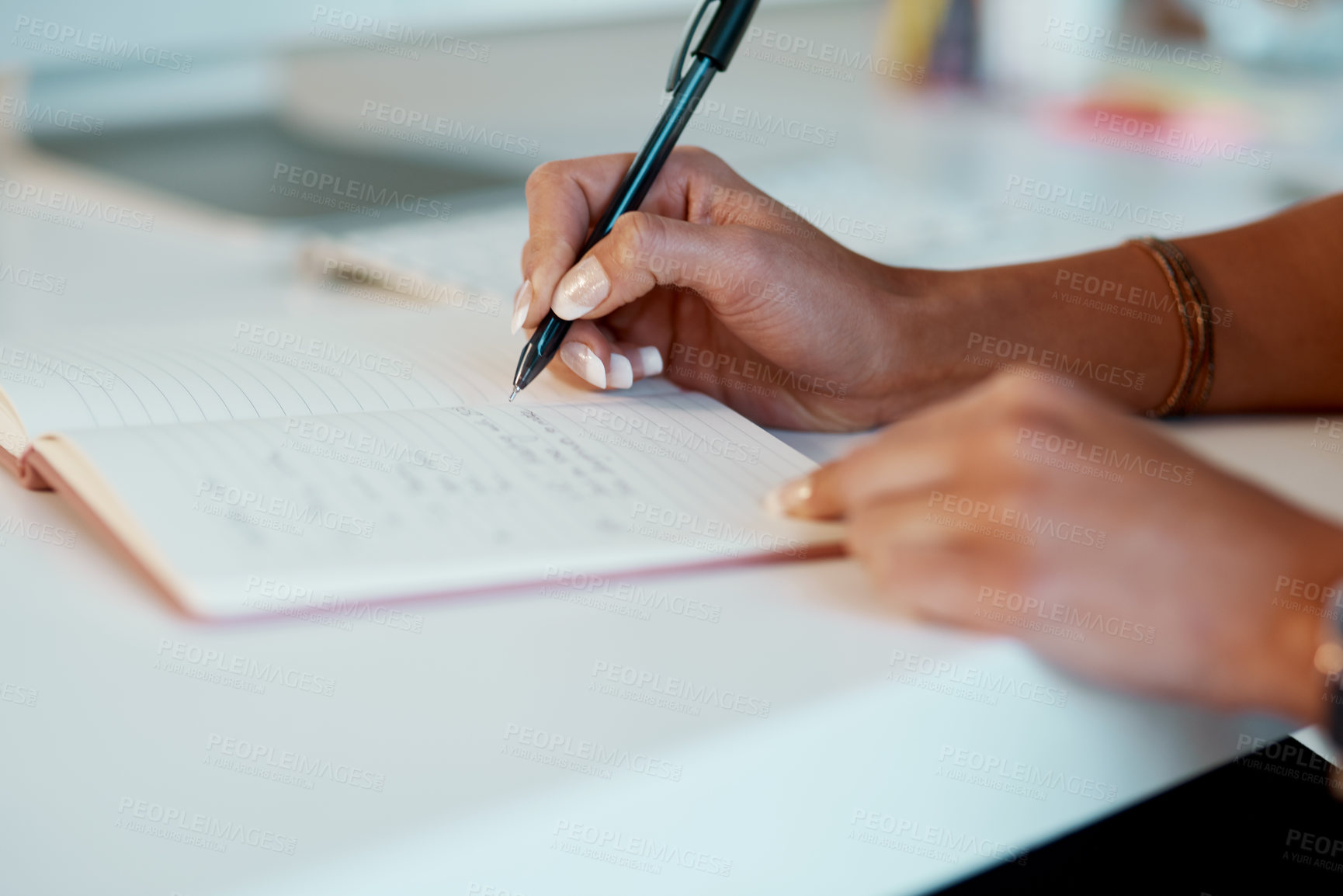 Buy stock photo Cropped shot of an unrecognizable businesswoman sitting alone and writing notes in her office