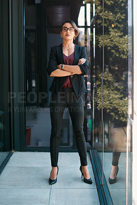 Buy stock photo Full length portrait of an attractive young businesswoman standing alone with her arms folded in her office
