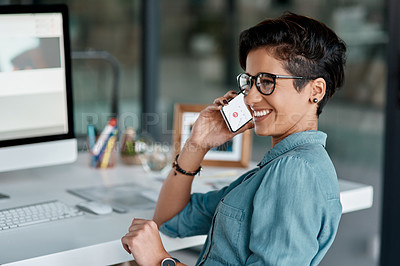 Buy stock photo Cropped shot of an attractive young businesswoman sitting alone in her office and talking on her cellphone