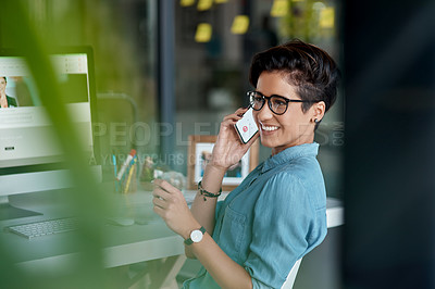 Buy stock photo Cropped shot of an attractive young businesswoman sitting alone in her office and talking on her cellphone