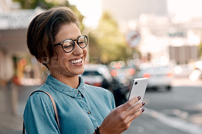 Buy stock photo Cropped shot of an attractive young woman standing outside on the street and using her cellphone to text
