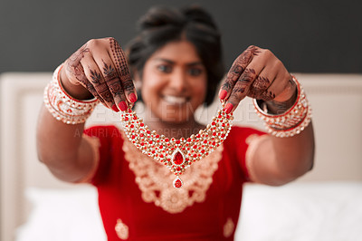 Buy stock photo Cropped shot of a beautiful young bride holding up the necklace piece she's going to wear in her dressing room