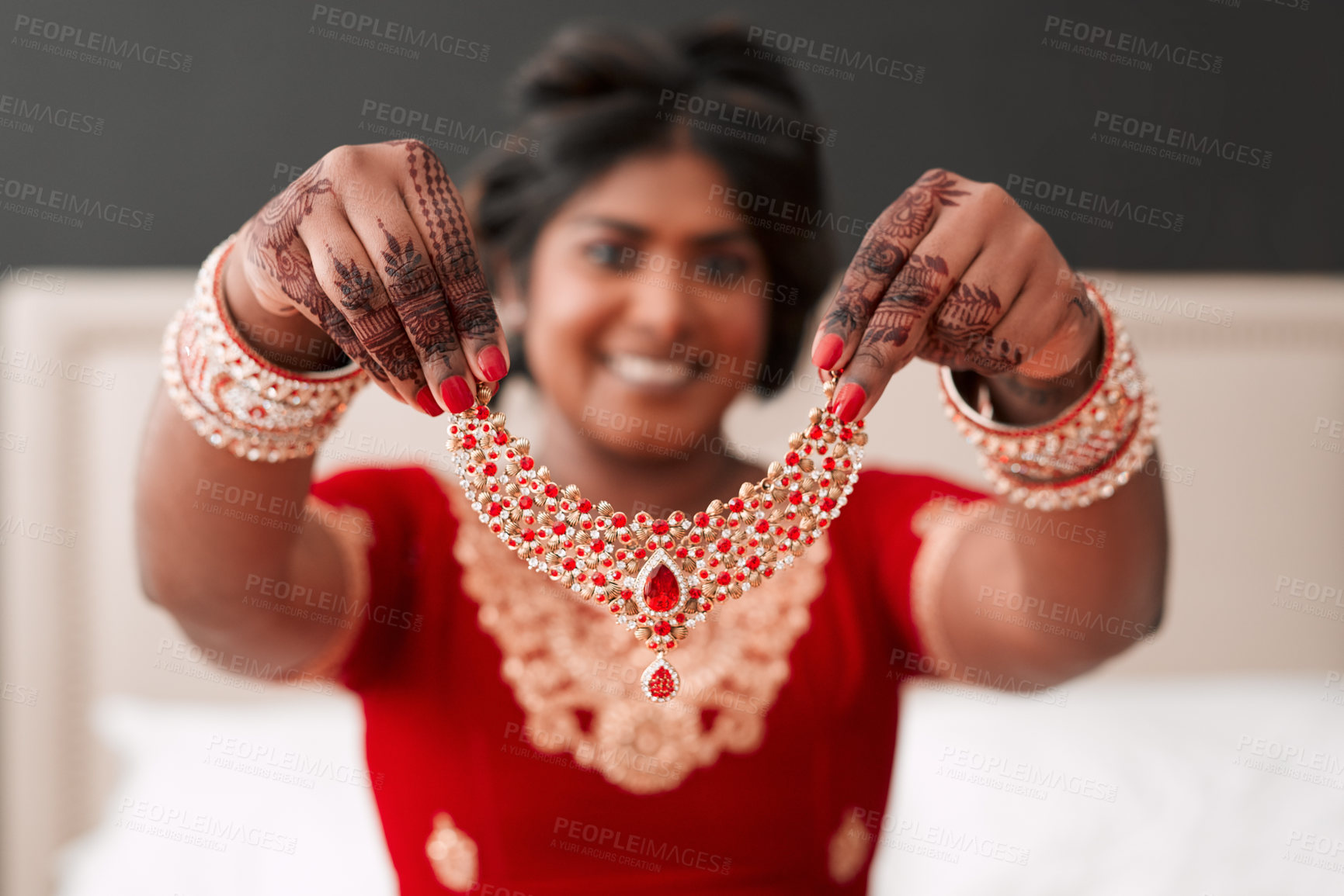 Buy stock photo Cropped shot of a beautiful young bride holding up the necklace piece she's going to wear in her dressing room