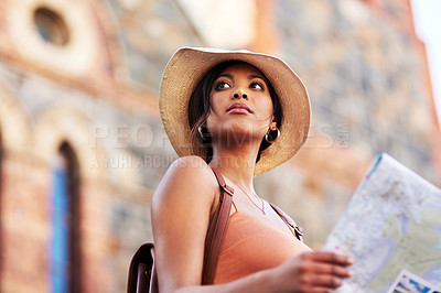 Buy stock photo Shot of an attractive young woman holding a map while exploring in a foreign city