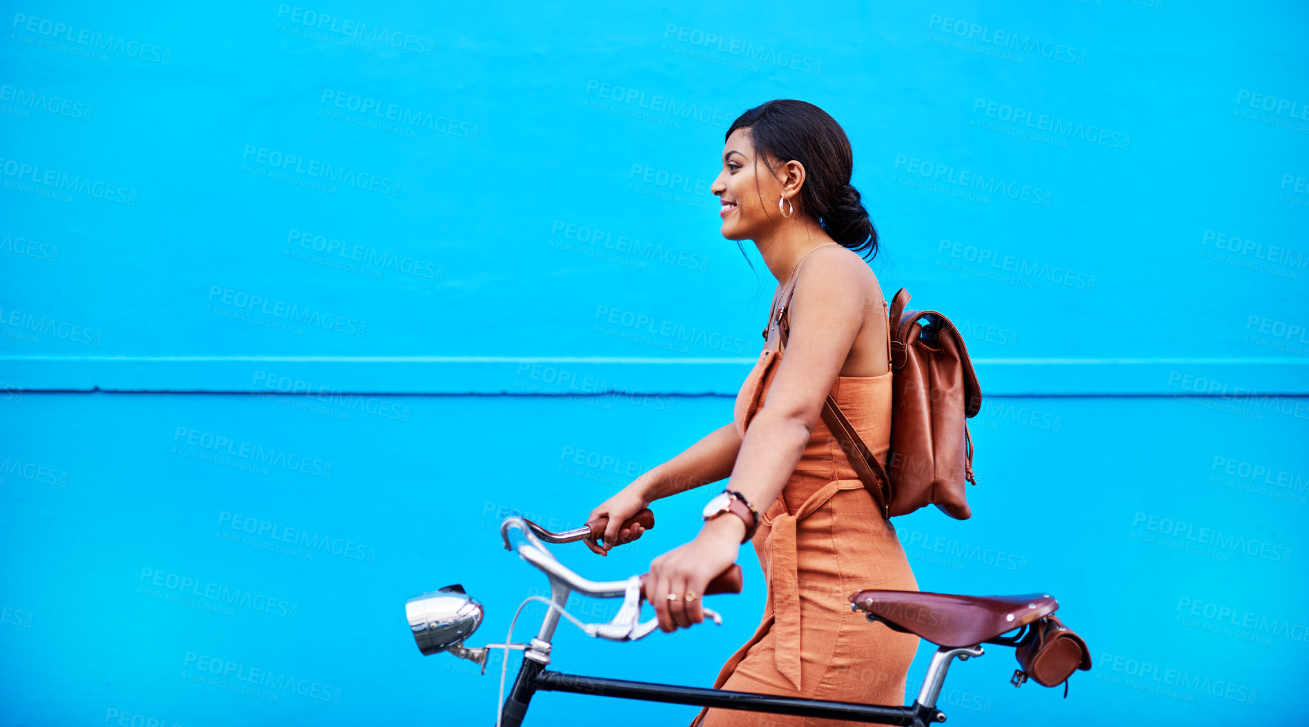 Buy stock photo Bicycle, travel and woman by wall in city for sustainable transport for adventure, journey or sightseeing. Happy, tourism and person with bike on holiday, vacation or trip by blue background in town.