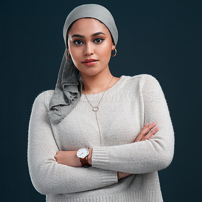 Buy stock photo Cropped shot of an attractive young woman wearing a headscarf and standing with her arms folded against a black background