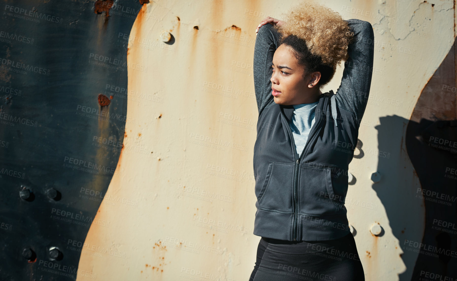 Buy stock photo Shot of a young woman warming up before her workout outdoors