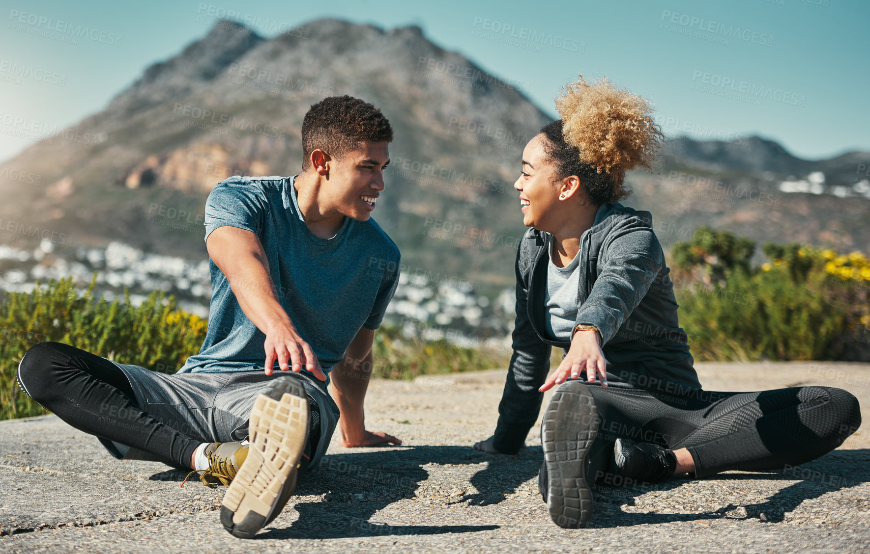 Buy stock photo Shot of a young couple warming up before their run