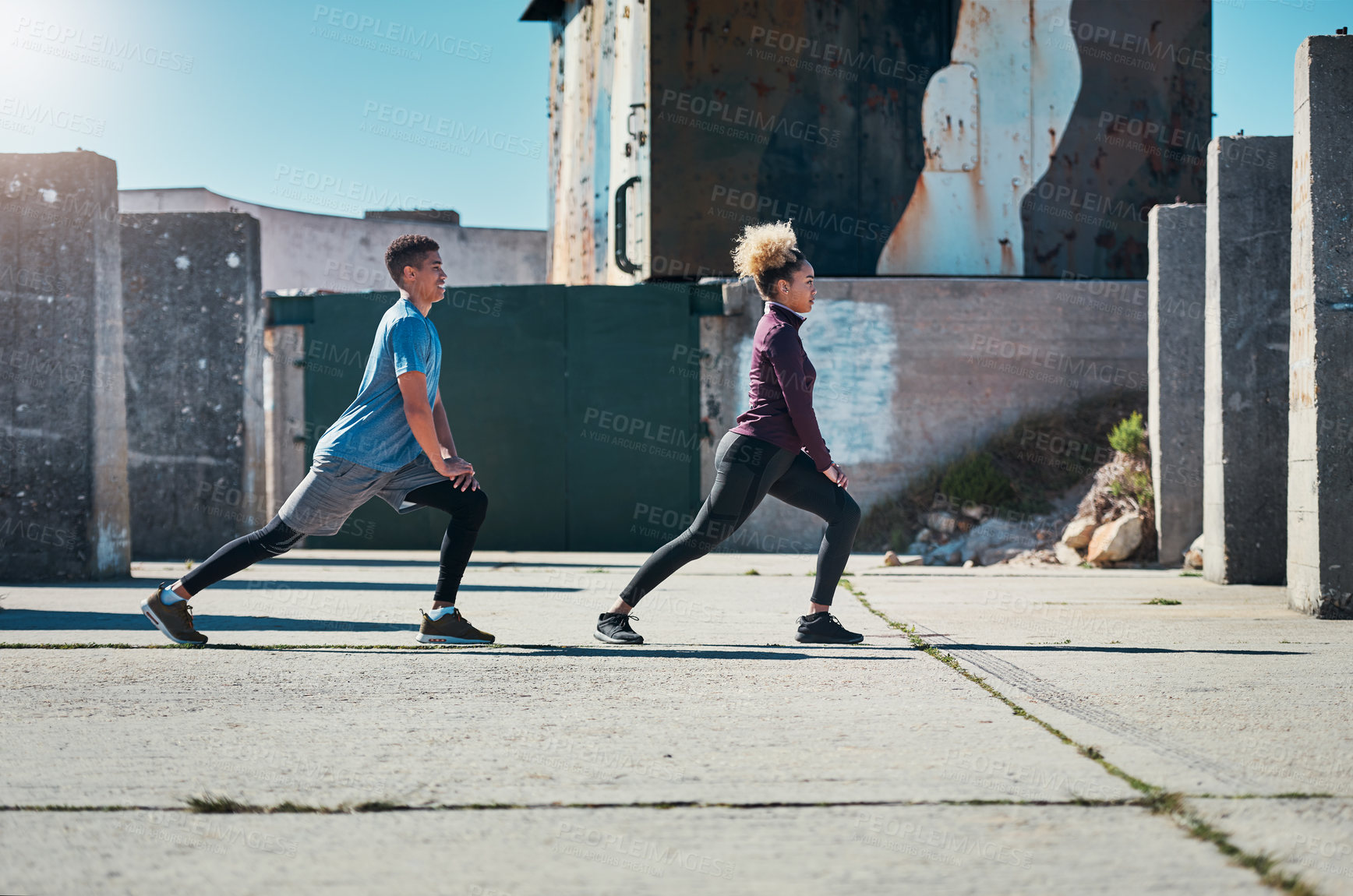 Buy stock photo Shot of a young couple warming up before their run