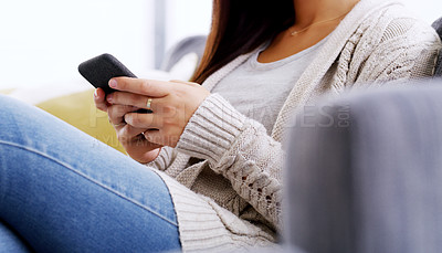 Buy stock photo Shot of an unrecognizable woman using her cellphone while relaxing on couch at home