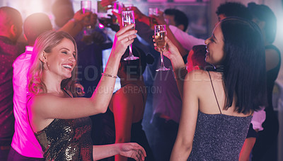 Buy stock photo Shot of two young women toasting with their drinks while dancing in a nightclub