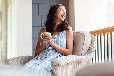 Buy stock photo Shot of a young woman drinking coffee while relaxing on the porch at home