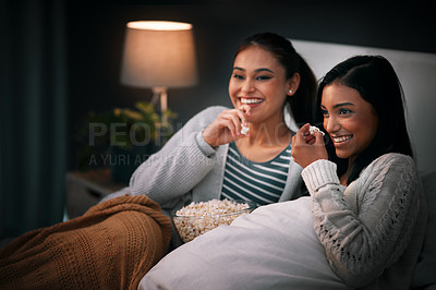 Buy stock photo Laughing, popcorn and women watching tv, movies or show at home for sleepover with streaming service and comedy. Gen z people relax in bedroom with funny TV film, cinema subscription and internet