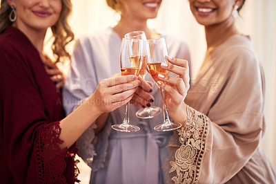 Buy stock photo Cropped shot of an unrecognizable bride and her bridesmaids making a toast with wineglasses in their dressing room before the wedding