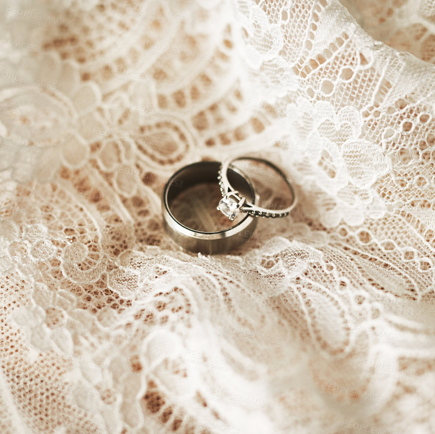 Buy stock photo Still life shot of two beautiful wedding rings on top of a wedding dress