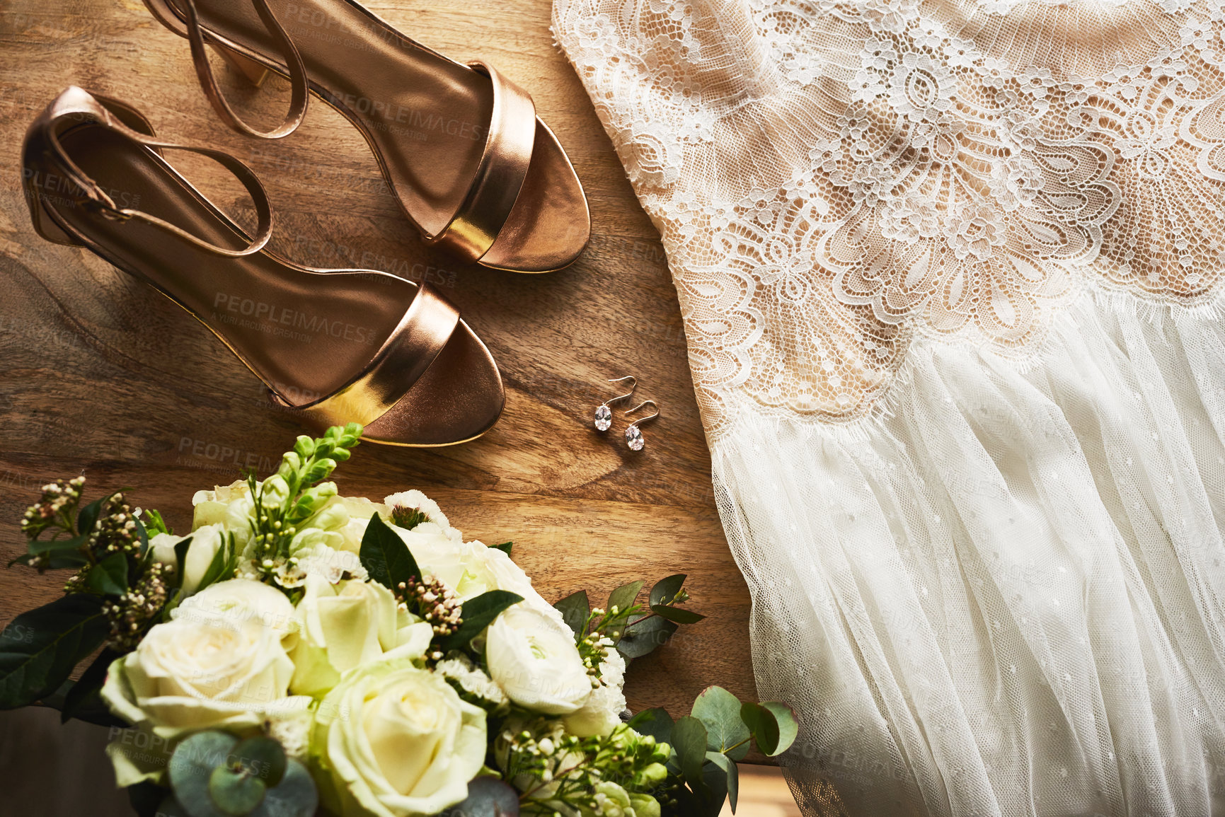 Buy stock photo Still life shot of a bride's shoes, wedding dress and bouquet on a wooden floor