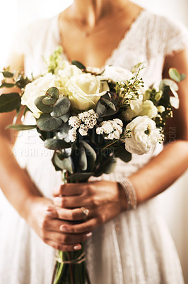 Buy stock photo Cropped shot of an unrecognizable bride holding a bouquet of flowers on her wedding day