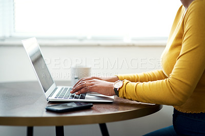 Buy stock photo Cropped shot of an unrecognizable woman sitting alone and using her laptop while at home