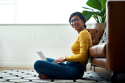 Buy stock photo Cropped shot of an attractive young woman sitting crosslegged on the floor and using her laptop at home