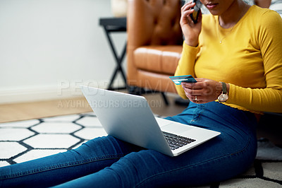 Buy stock photo Cropped shot of an unrecognizable woman sitting on her floor at home and using technology for online shopping