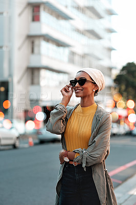 Buy stock photo Cropped shot of an attractive young woman wearing sunglasses and a hijab while standing alone in the city