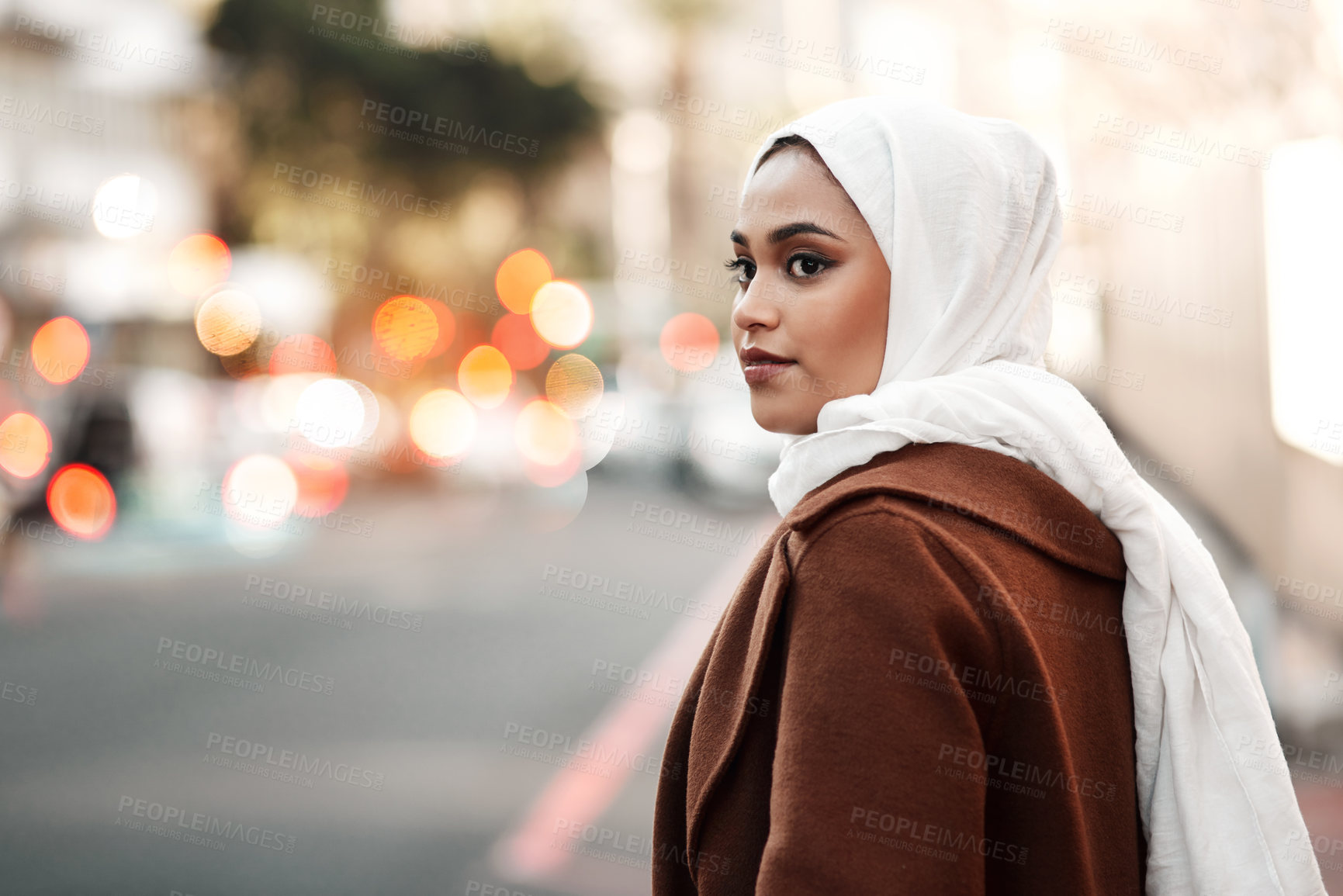 Buy stock photo Cropped shot of an attractive young woman wearing a hijab and standing alone while touring the city