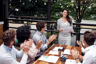 Buy stock photo Cropped shot of an attractive young businesswoman standing and giving a presentation to her seated colleagues outdoors