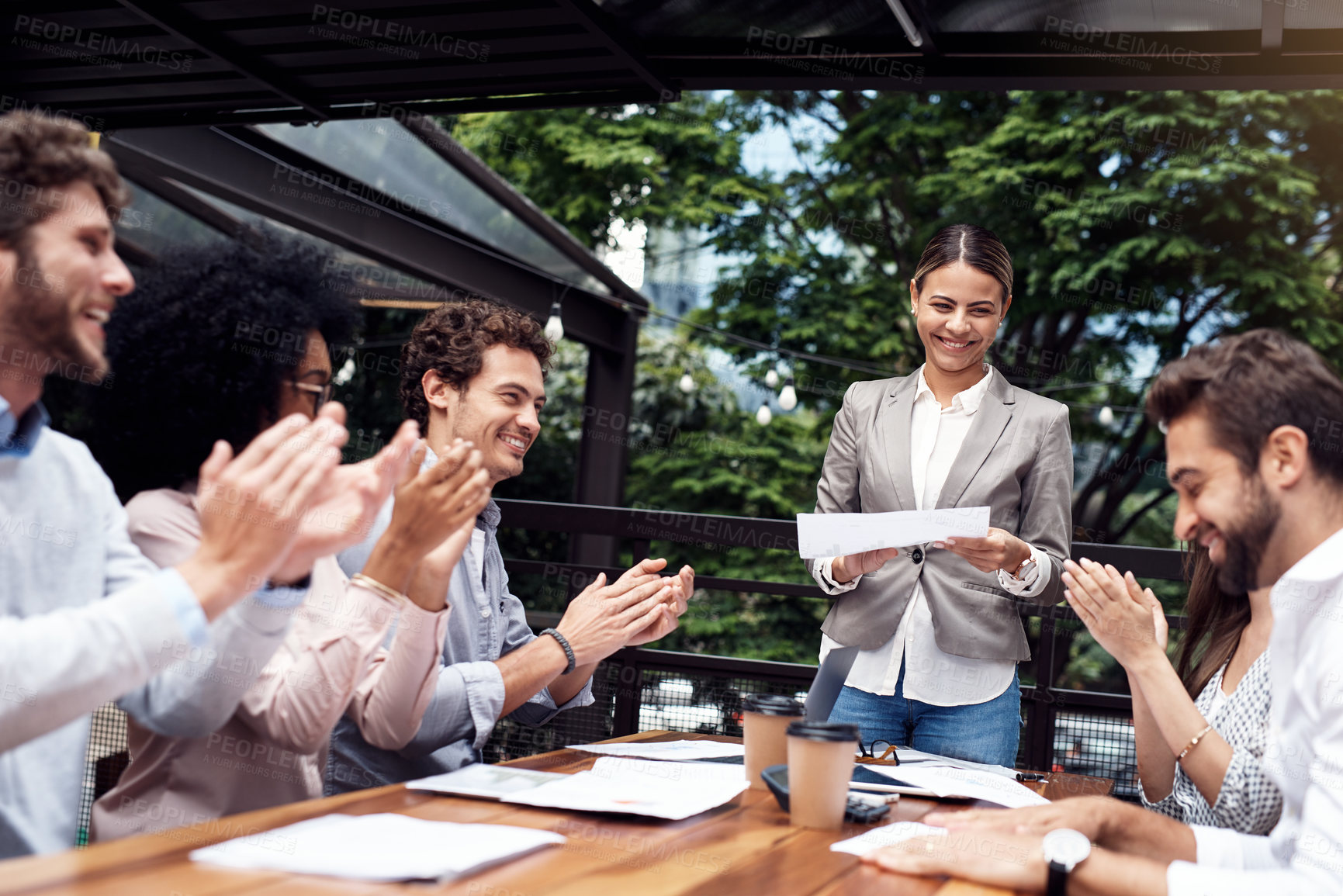 Buy stock photo Cropped shot of an attractive young businesswoman standing and giving a presentation to her seated colleagues outdoors